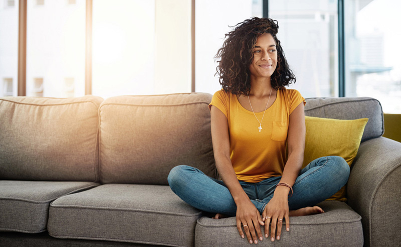 Full length shot of an attractive young woman looking thoughtful while relaxing at home on the weekend