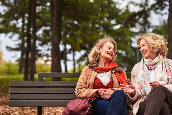 Two senoir woman laughing at the park