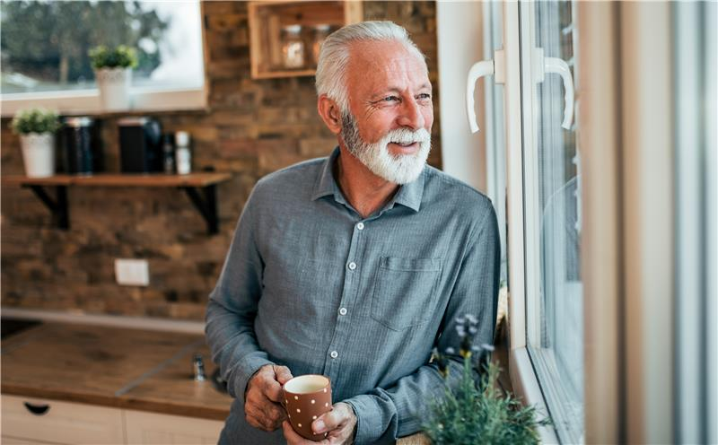 Older man leaning against window