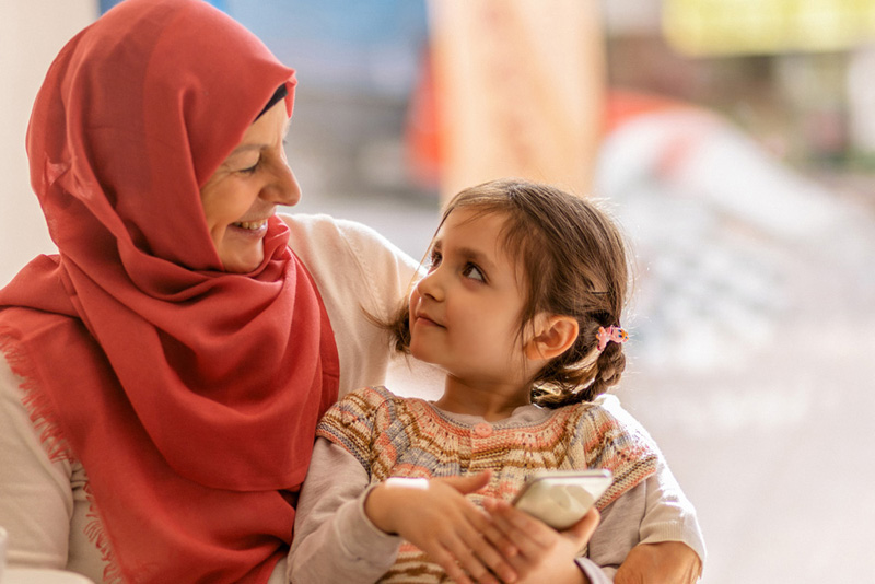 Muslim mom her daughter sitting on lap