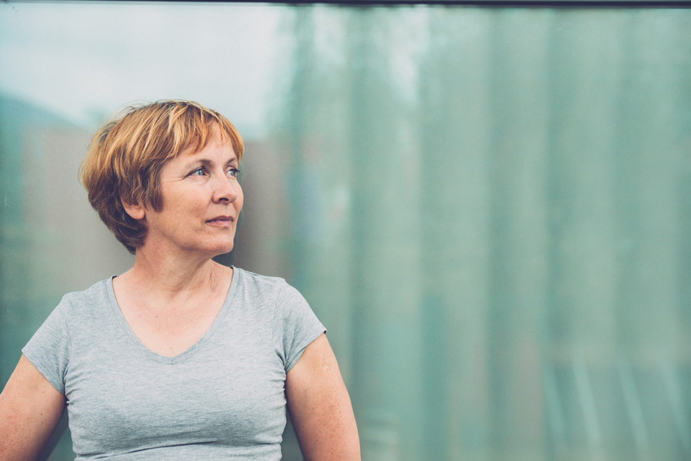 Independent Senior woman with short hair against window glass reflection portrait - outdoors photography. Slovenia, Europe. All logos removed. Nikon D800, full frame, Nikkor 70.0-200.0 mm, aperture 2.8, Copy space.