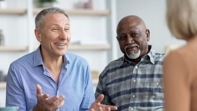 Elderly man talking with man and woman
