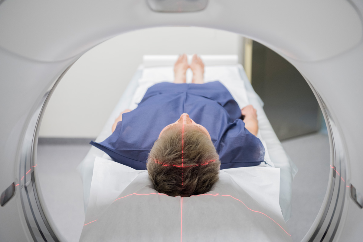 Person lying in a CT scanner in hospital. PET scan equipment. Medical scan of patient.