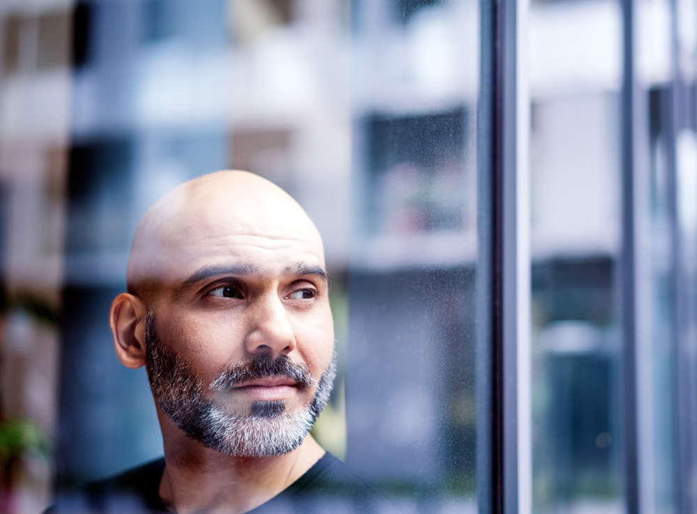 878402296 Thoughtful mature businessman looking away in office. Male professional is seen through window. He is at workplace.