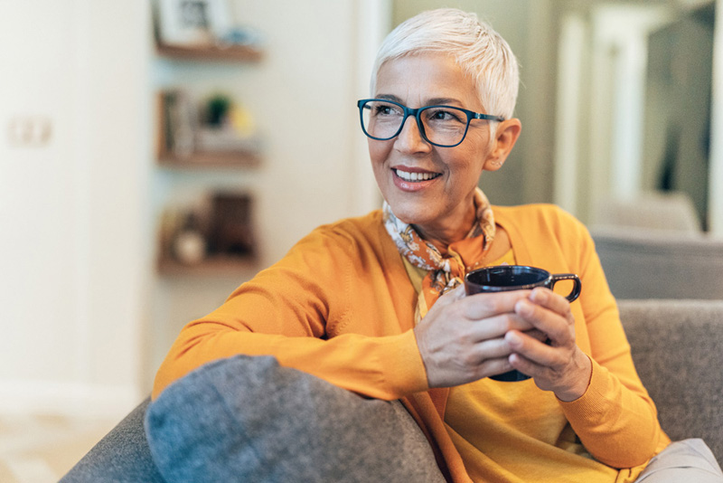 Senior woman at home with cup of hot drink