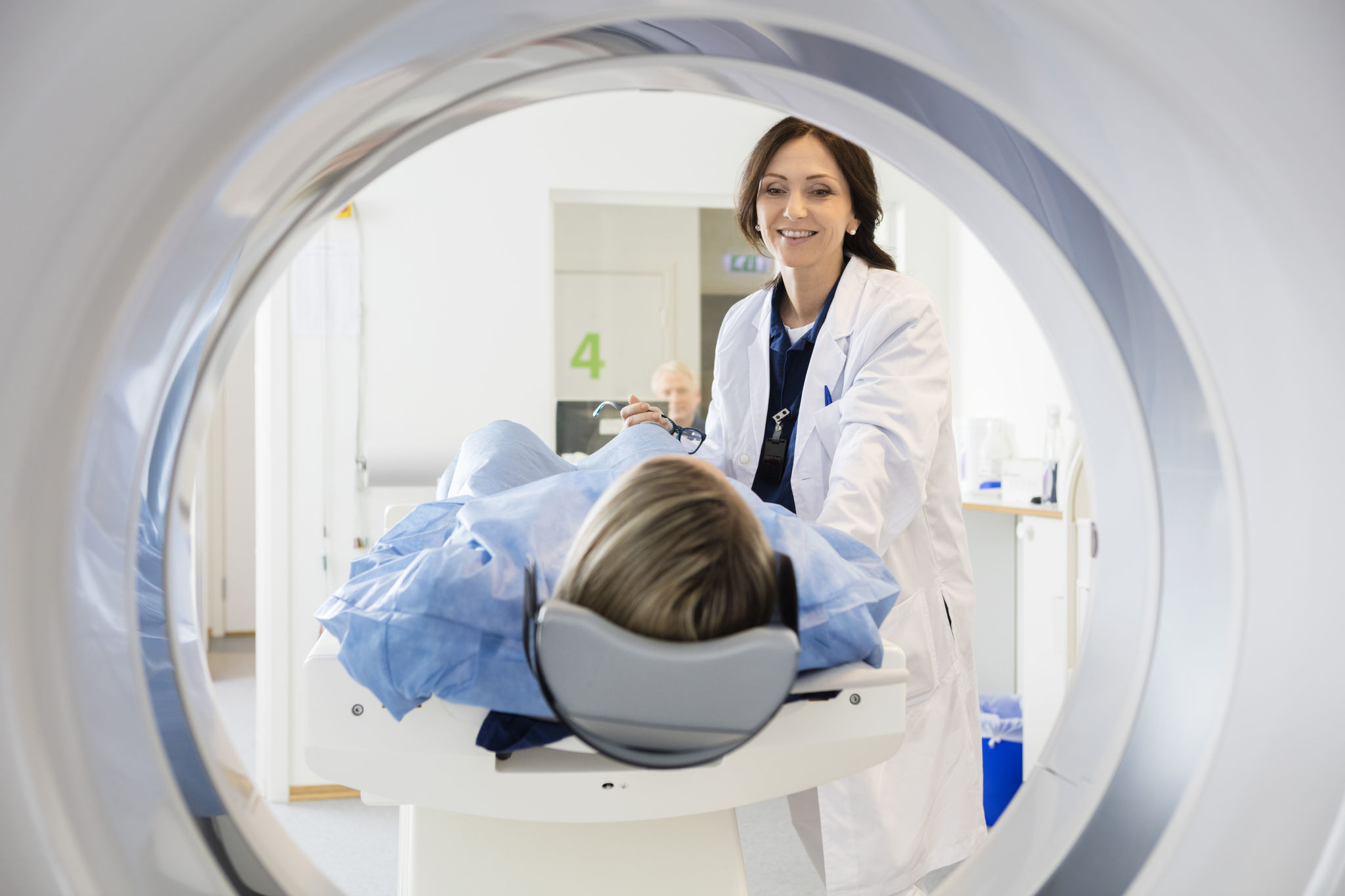 Female Doctor Looking At Patient Undergoing CT Scan; Shutterstock ID 476546674; purchase_order: Melissa McRae; job: Melissa McRae; client: Melissa McRae; other: melissa.mcrae@genesiscare.com