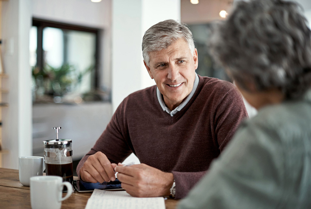 Shot of a mature man having a conversation with his wife blurred out in the foreground