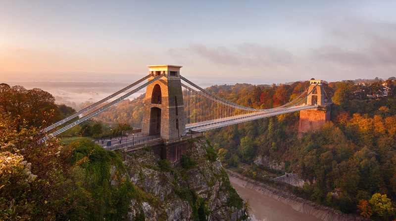 Clifton Suspension Bridge on an autumn morning as the sun rises and breaks through the clouds
