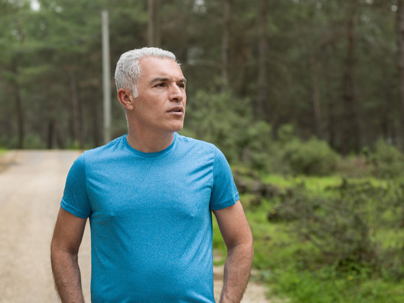 Mature adult man with gray hair running in outdoor. Shot in outdoor daylight with a medium format camera.