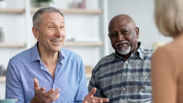 Elderly man talking with man and woman