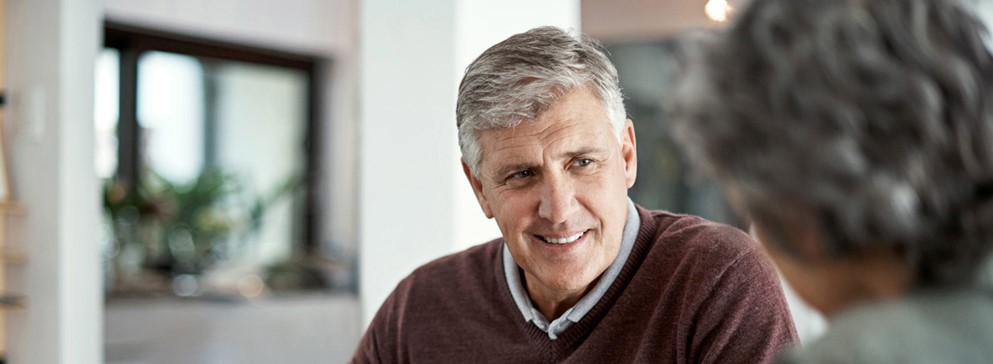 Shot of a mature man having a conversation with his wife blurred out in the foreground