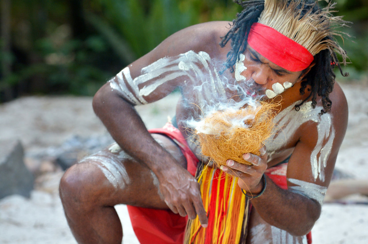 Portrait of one Yugambeh Aboriginal warrior demonstrate fire making craft during Aboriginal culture show in Queensland, Australia.