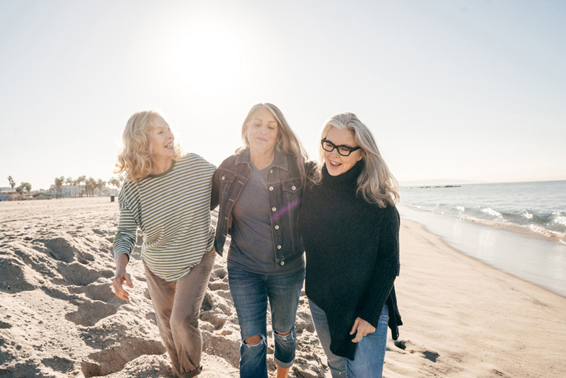 Three female friends embracing on a beach
