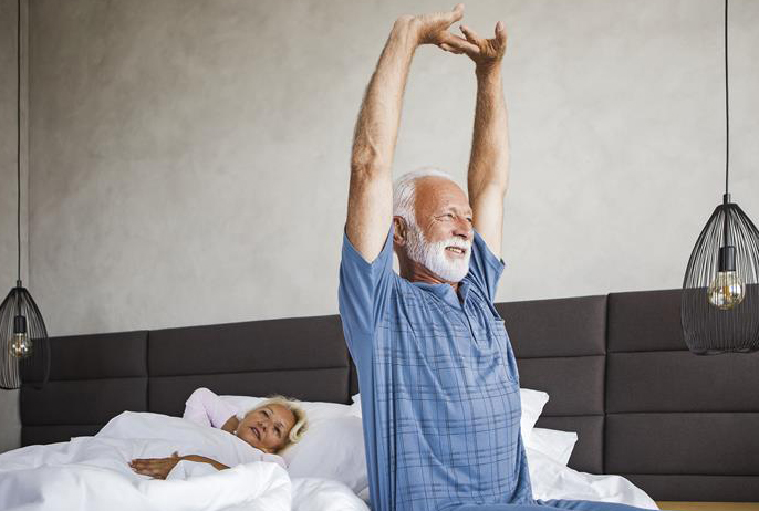 Man stretching on a bed