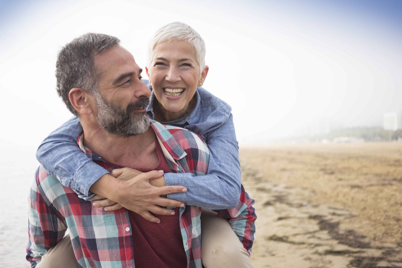 Pareja de personas mayores felices en la playa